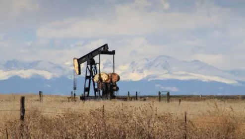 oil rig in field with mountains