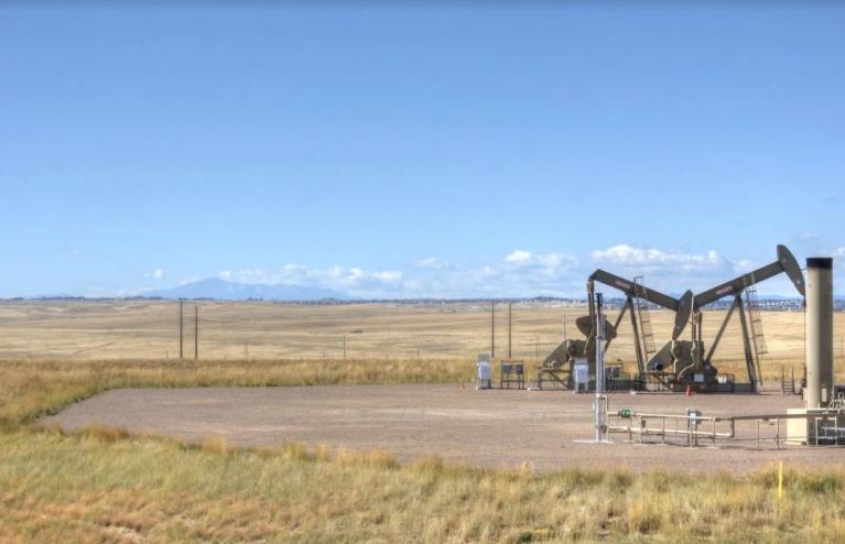 photograph of oil and gas extraction rig massive in a rural field in elbert county